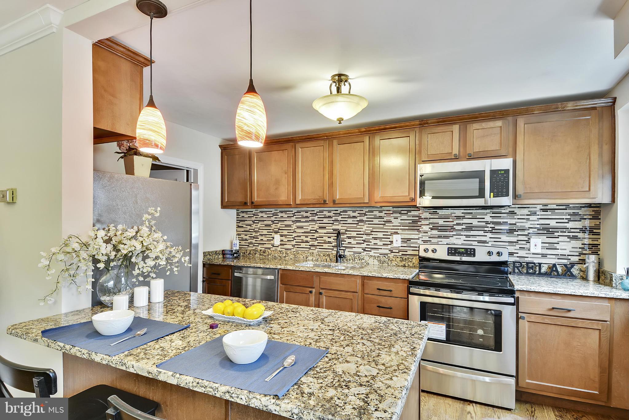 1602 Heathfield Road Baltimore, MD 21239 - Photo 2 of 27 a kitchen with stainless steel appliances granite countertop a sink a stove and a wooden floors