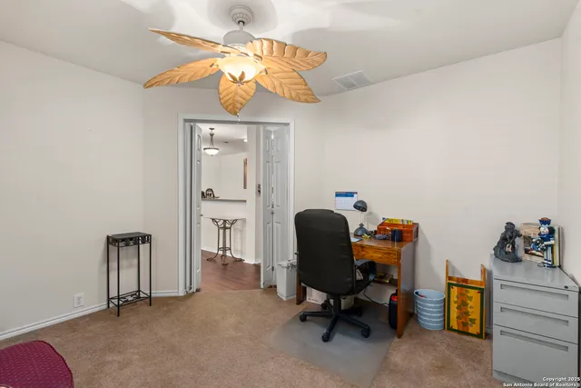 a view of a workspace with furniture and a window