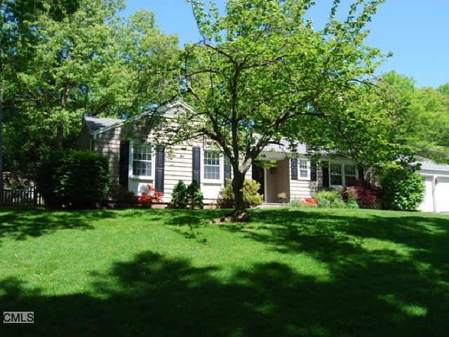 94 Harwich Road Fairfield, CT 06825 - Photo 1 of 1 a front view of a house with a garden and trees