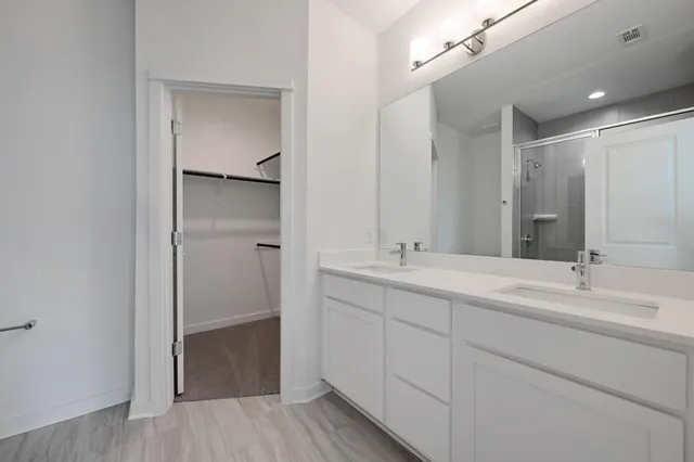 a bathroom with a double vanity sink mirror and shower