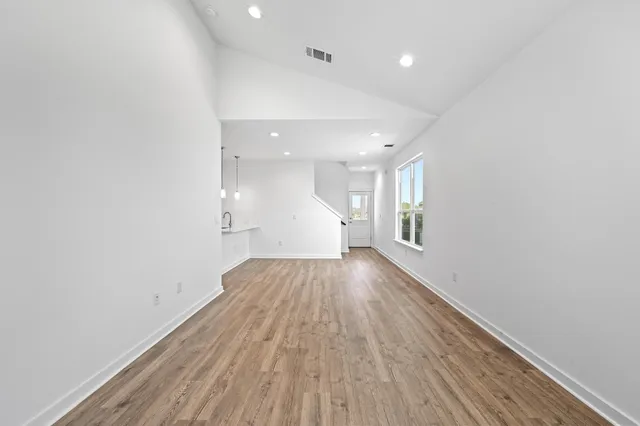 a view of empty room with wooden floor