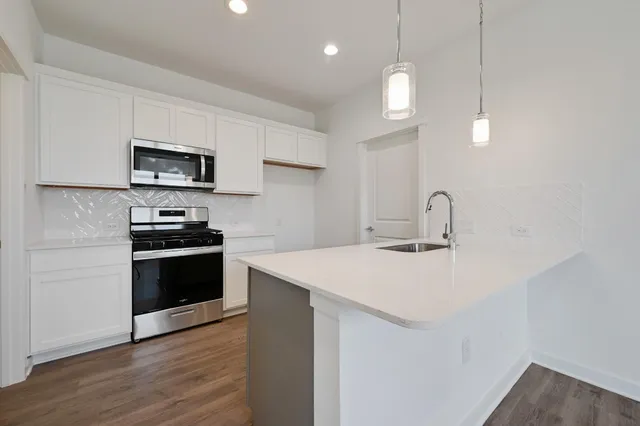 a kitchen with a sink a stove and microwave