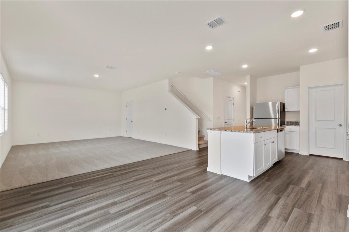 113 Rother Place Taylor, TX 76574 - Photo 33 of 34 Kitchen featuring open floor plan, white cabinets, appliances with stainless steel finishes, an island with sink, and recessed lighting