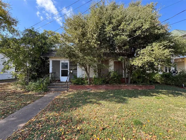 a view of a yard in front of a house with large trees