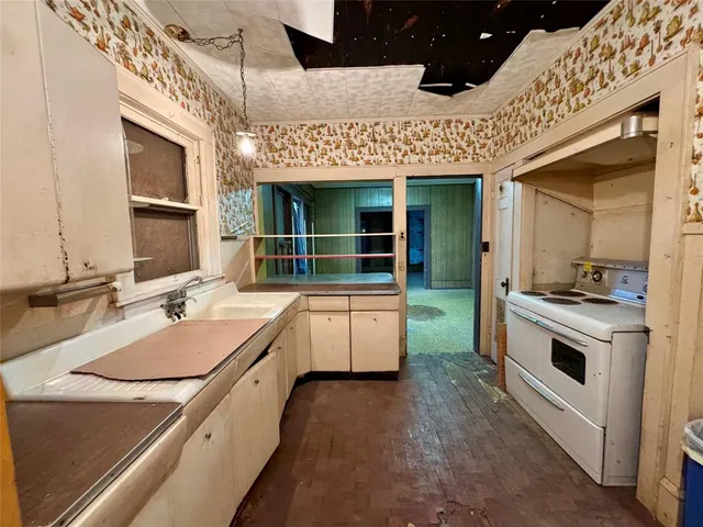 a large white kitchen with a stove and a sink