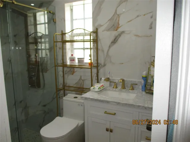 a bathroom with a granite countertop sink toilet and shower