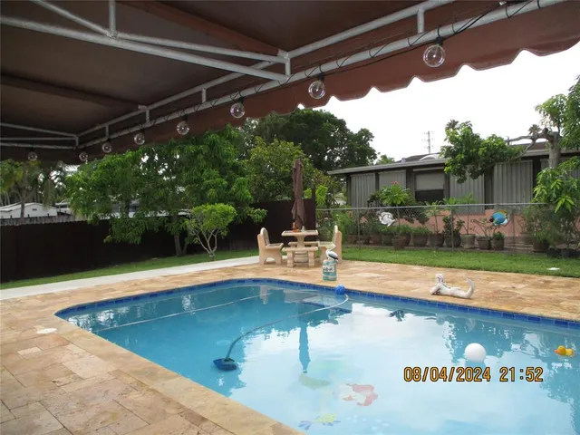a view of swimming pool with seating space and plants
