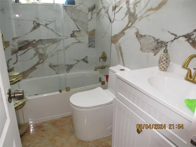 a white toilet sitting next to a bathroom sink and tub