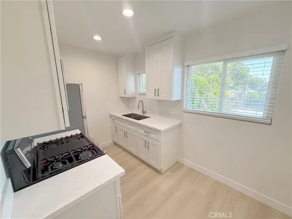 a kitchen with sink a stove and a refrigerator