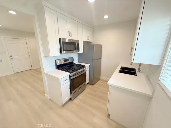 a kitchen with kitchen island a white counter top space and cabinets