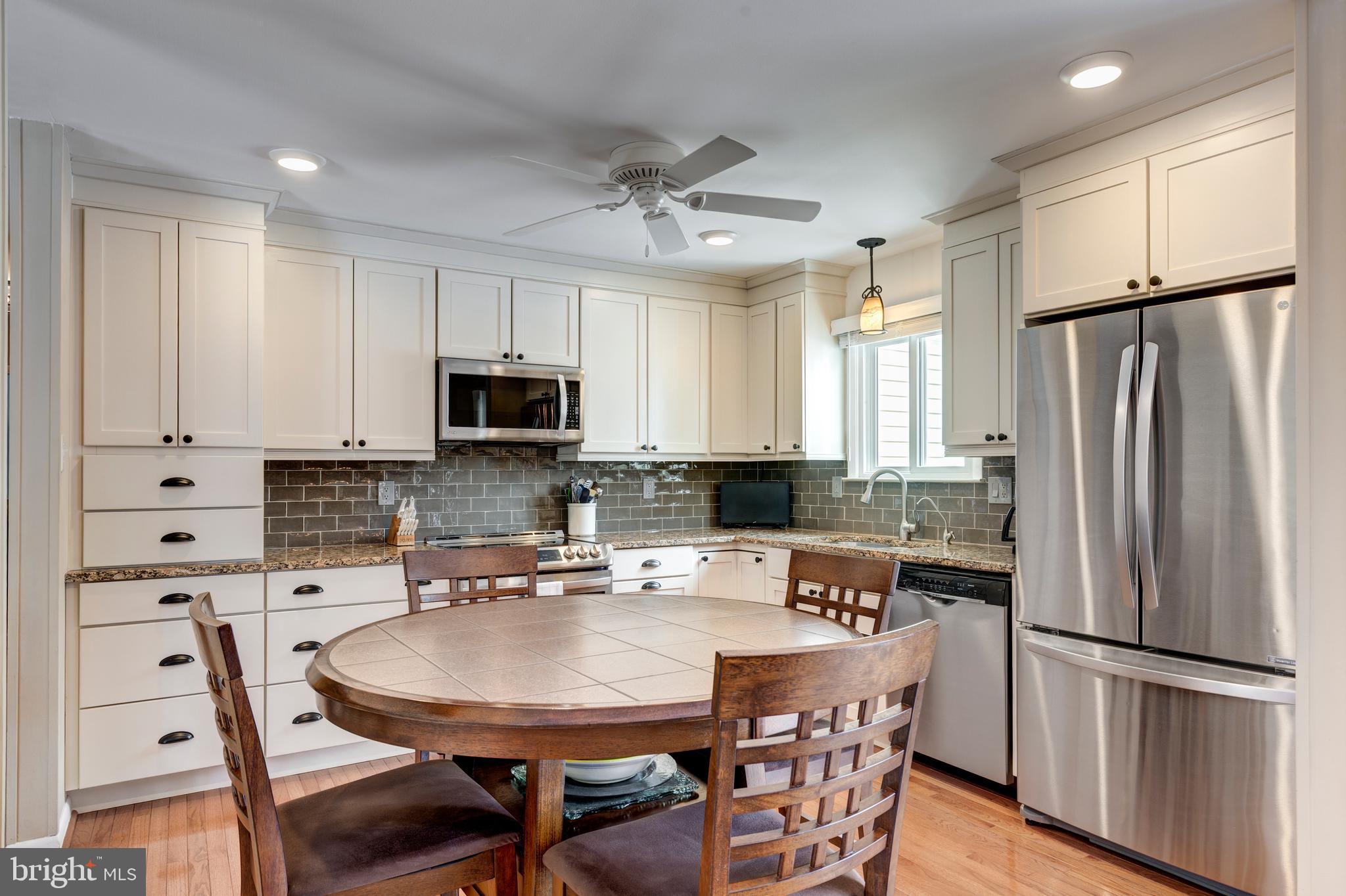 4316 Utz Road Hampstead, MD 21074 - Photo 17 of 82 a kitchen with stainless steel appliances a refrigerator a stove a dining table and chairs