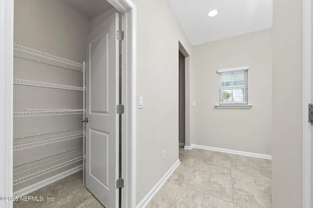 an empty room with windows and ceiling fan