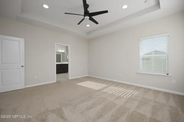 an empty room with windows and a ceiling fan