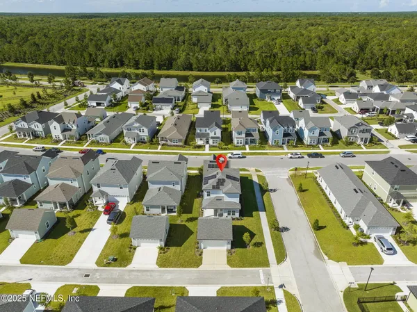 an aerial view of residential houses with outdoor space and swimming pool