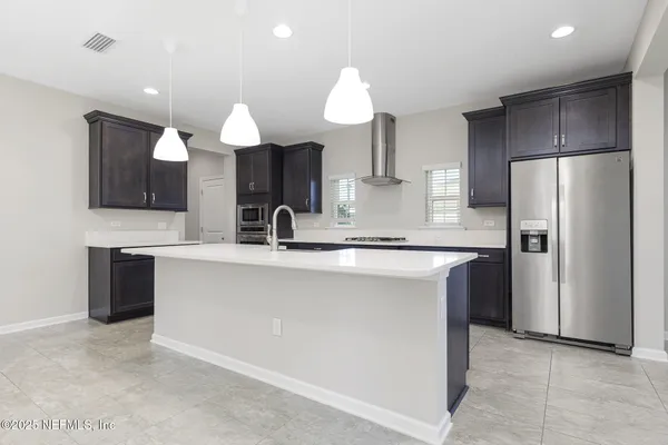 a kitchen with kitchen island granite countertop a sink counter top space appliances and cabinets