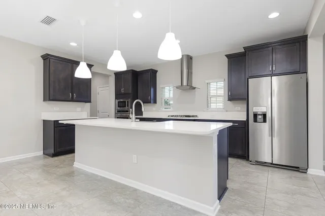 a kitchen with kitchen island granite countertop a sink counter top space appliances and cabinets