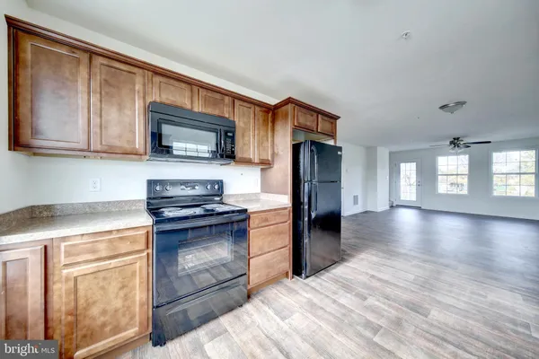 a kitchen with granite countertop wooden cabinets stainless steel appliances and a window