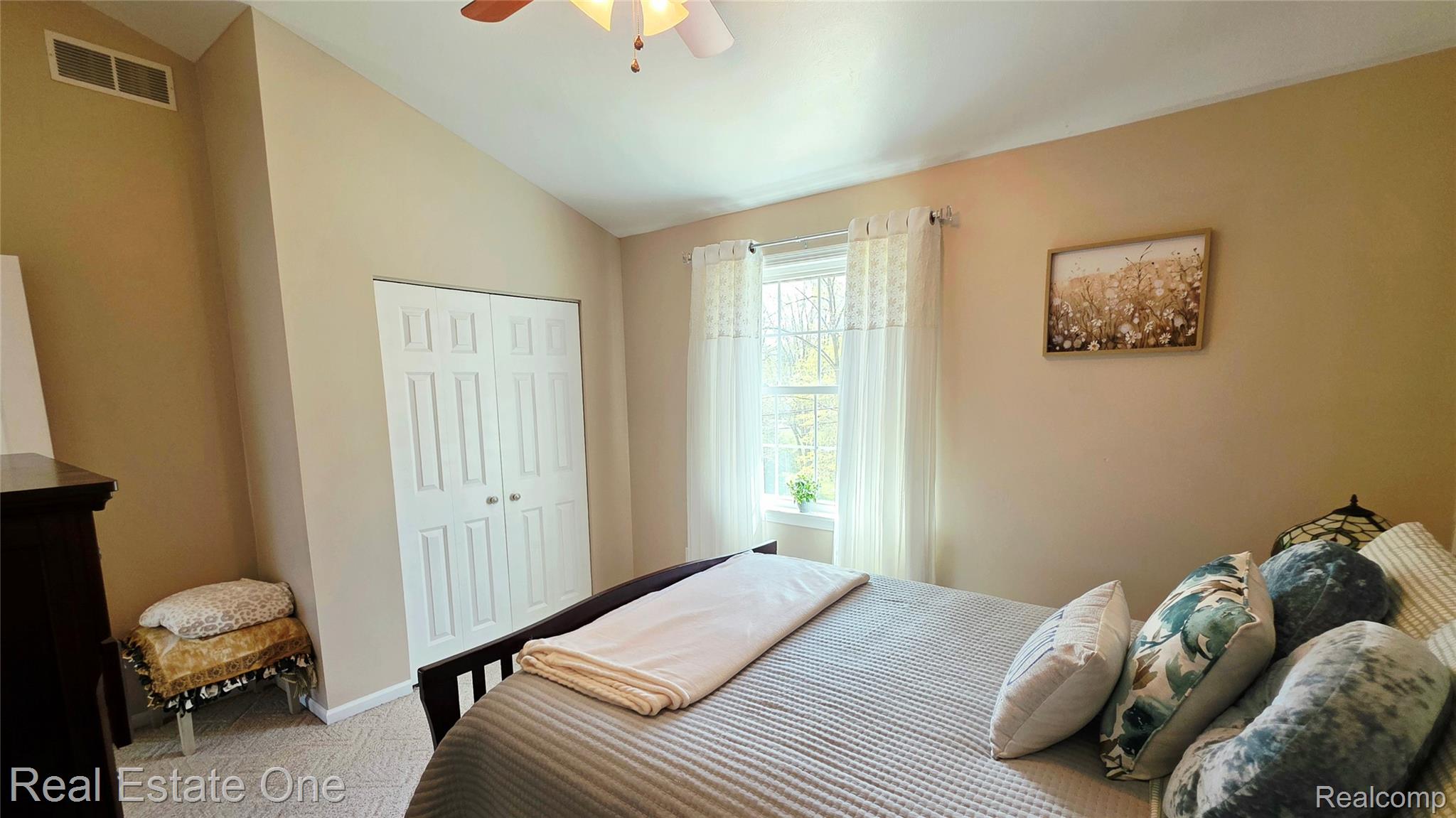 8751 Highland Road Watervliet, MI 49098 - Photo 13 of 16 Bedroom 2 with a closet, vaulted ceiling, a ceiling fan, and light colored carpet