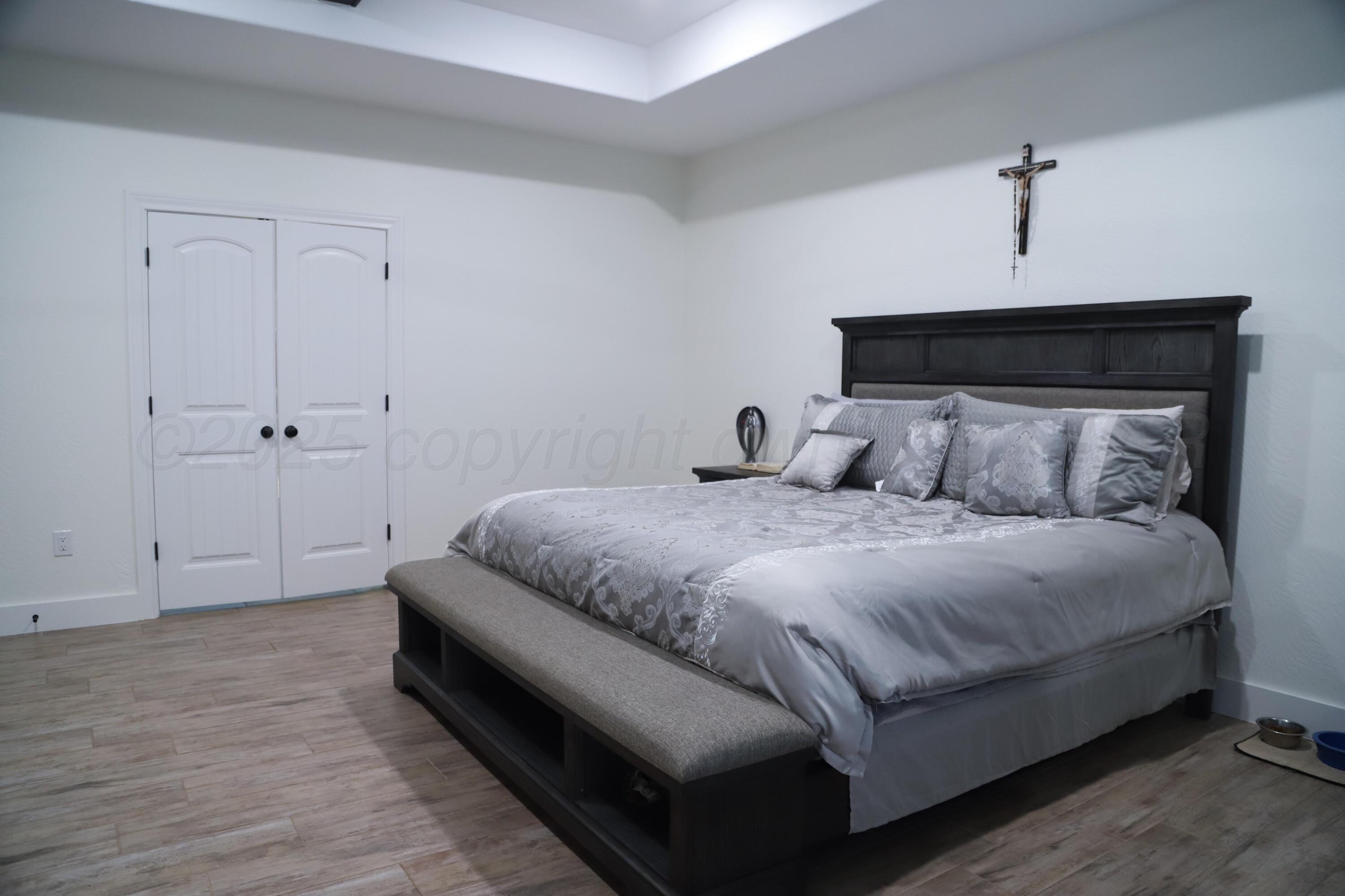 11501 Cutter Lane Amarillo, TX 79118 - Photo 12 of 24 a bedroom with a bed and wooden floor