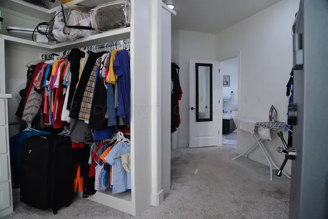 a view of walk in closet with clothes and shoes