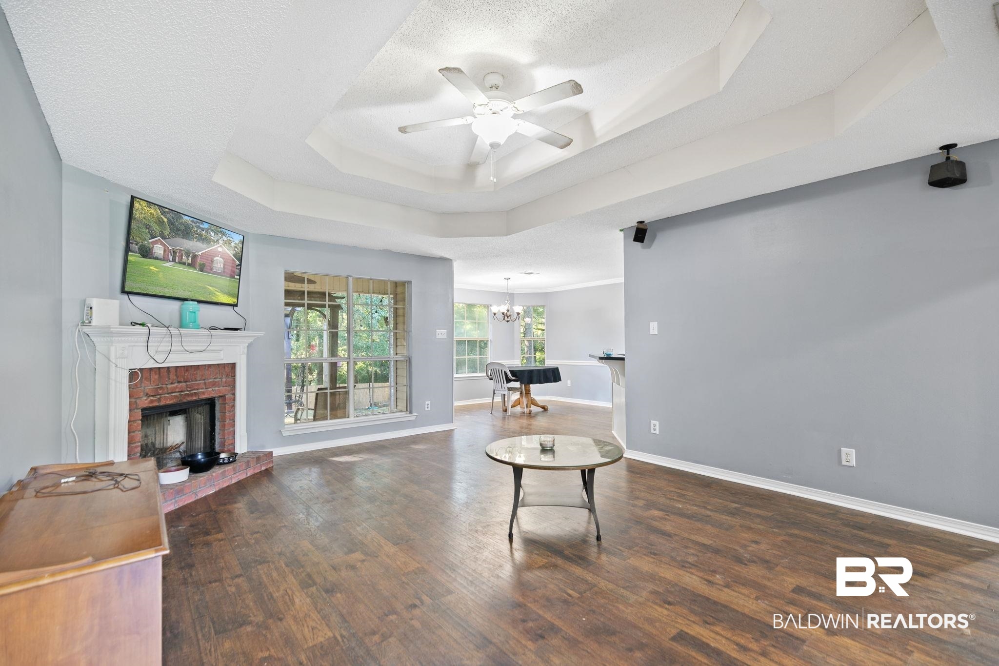 10550 Patrick Avenue Grand Bay, AL 36541 - Photo 8 of 43 Living room with hardwood / wood-style flooring, a raised ceiling, ceiling fan with notable chandelier, and a fireplace