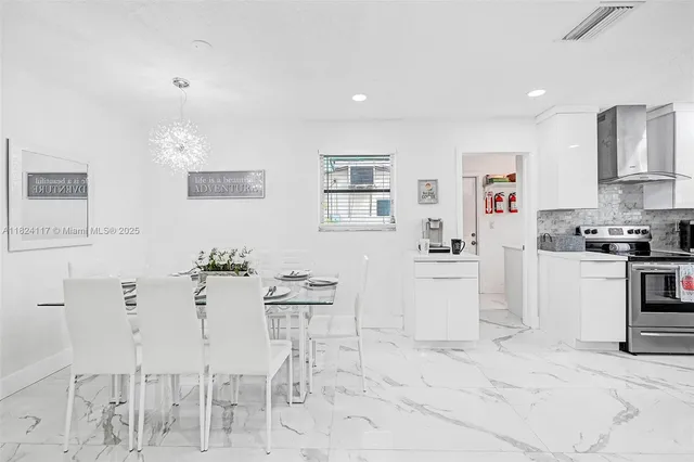 a kitchen with granite countertop white cabinets and chairs