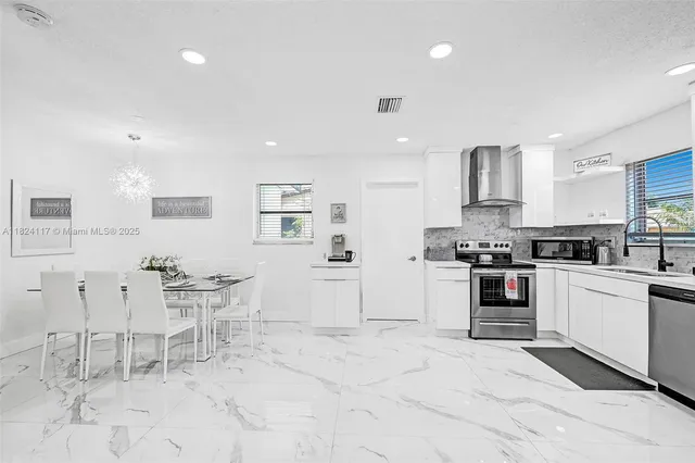 a kitchen with granite countertop a stove a sink and a refrigerator