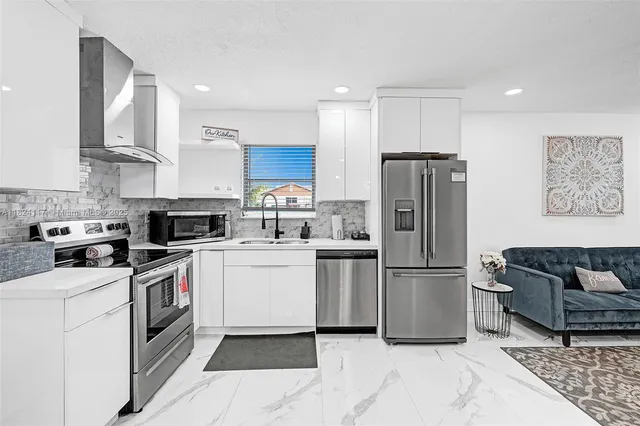 a kitchen with stainless steel appliances granite countertop a refrigerator sink and stove