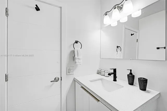 a bathroom with a sink vanity and shower
