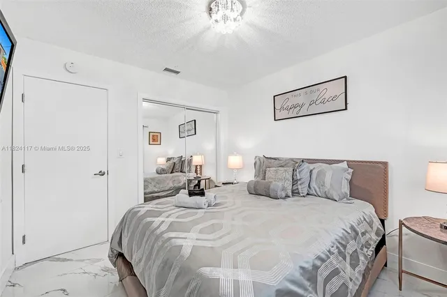 a bedroom with a bed and a chandelier