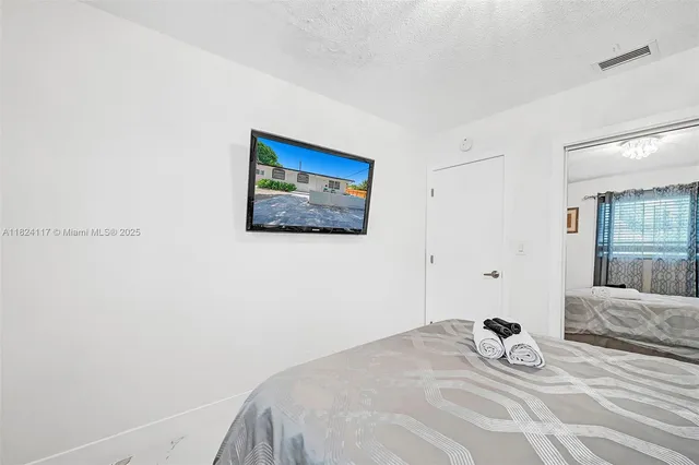 a bedroom with a bed and a painting on the wall