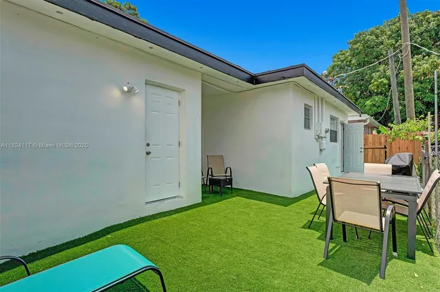 a backyard of a house with table and chairs