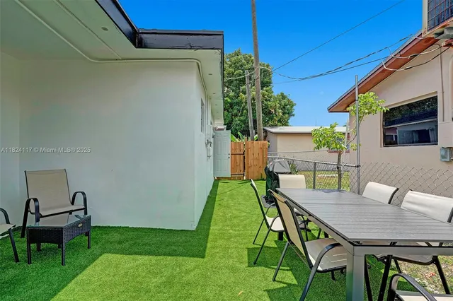 a backyard of a house with table and chairs