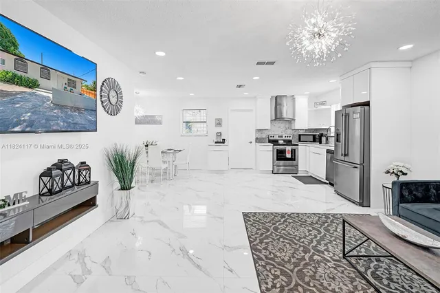 a kitchen with stainless steel appliances granite countertop a refrigerator and a stove top oven