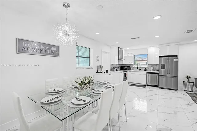 a view of kitchen with sink refrigerator dining table and chairs