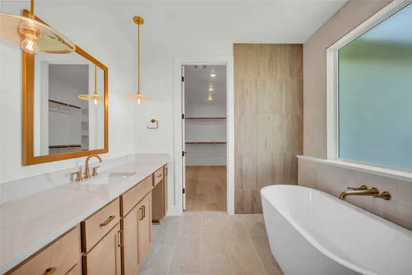 a bathroom with a tub sink and mirror