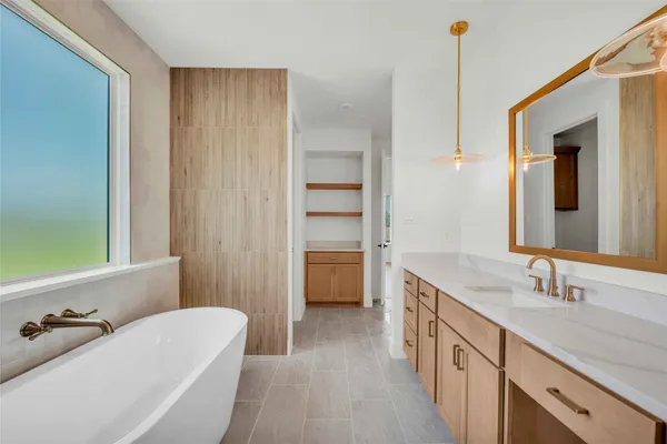 a bathroom with a tub sink and mirror