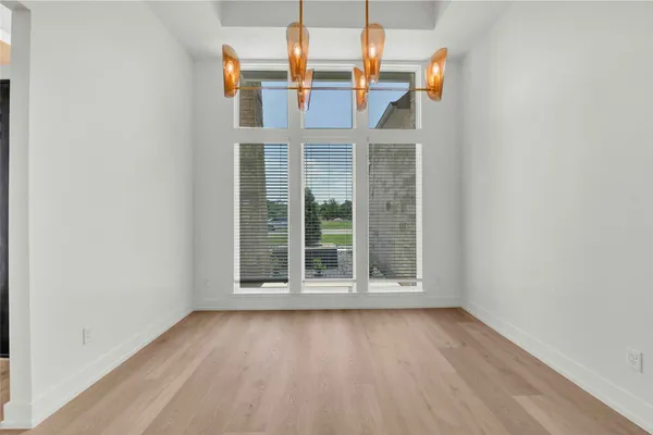 an empty room with wooden floor and window