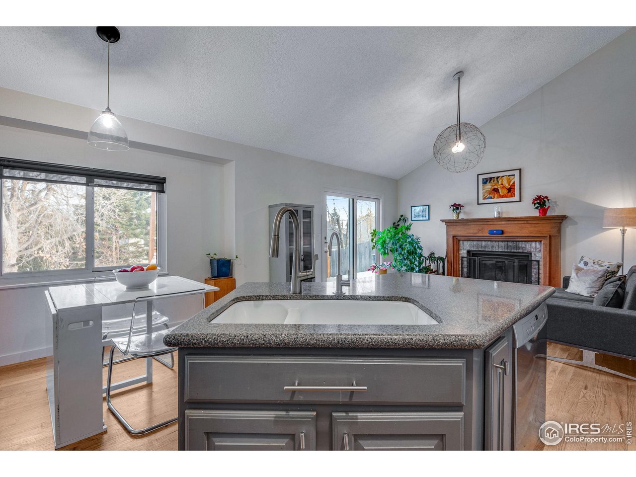 908 Clover Circle Lafayette, CO 80026 - Photo 12 of 40 a living room with kitchen island furniture and a flat screen tv