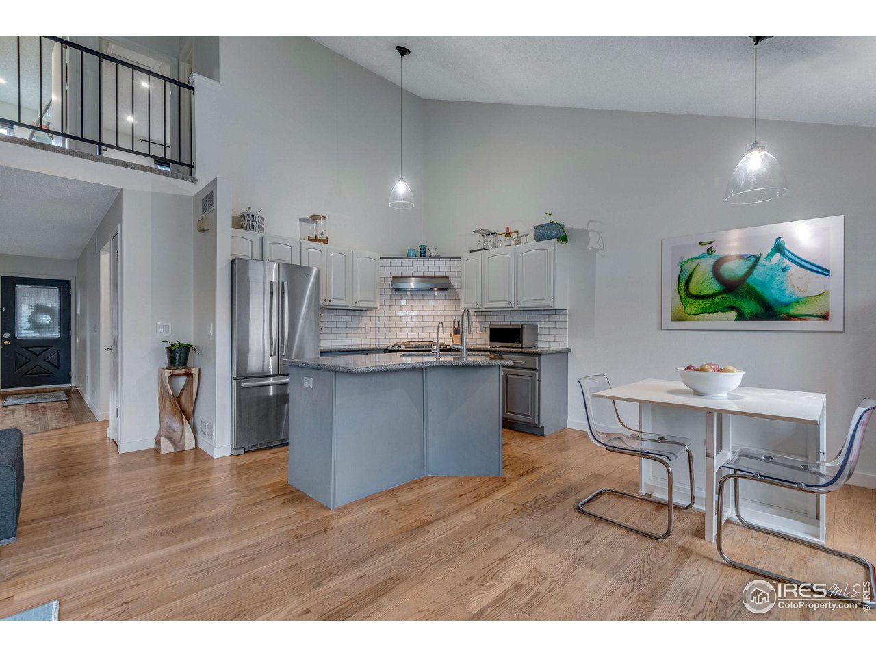 908 Clover Circle Lafayette, CO 80026 - Photo 13 of 40 a kitchen with stainless steel appliances kitchen island granite countertop a refrigerator a stove a sink dishwasher and wooden cabinets with wooden floor