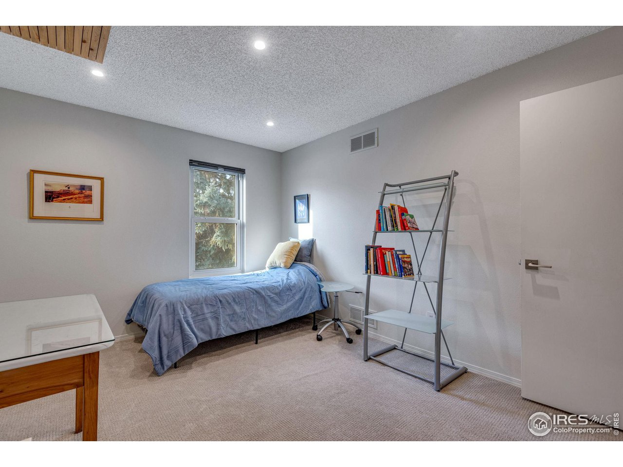 908 Clover Circle Lafayette, CO 80026 - Photo 22 of 40 a bedroom with a bed and a chandelier