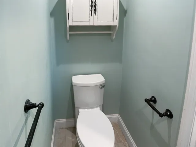 a white toilet sitting next to a window