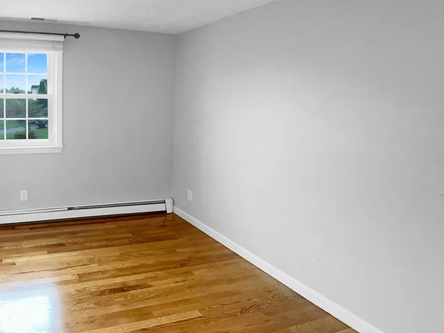 a view of a room with wooden floor and a window
