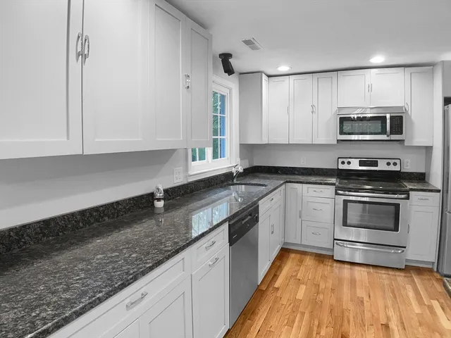 a kitchen with stainless steel appliances granite countertop a sink a stove top oven and granite counter tops