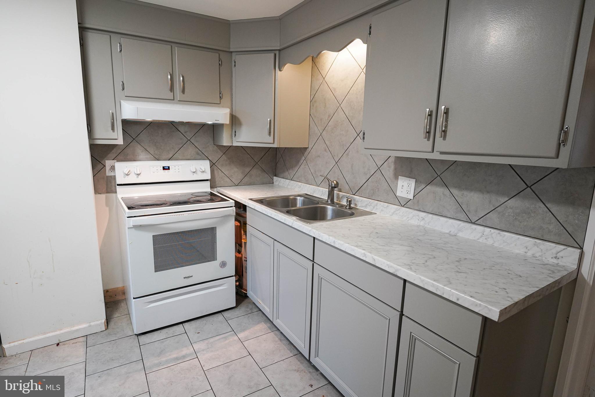 231 Newton Street, Unit A Salisbury, MD 21801 - Photo 28 of 38 a kitchen with a sink stove and cabinets