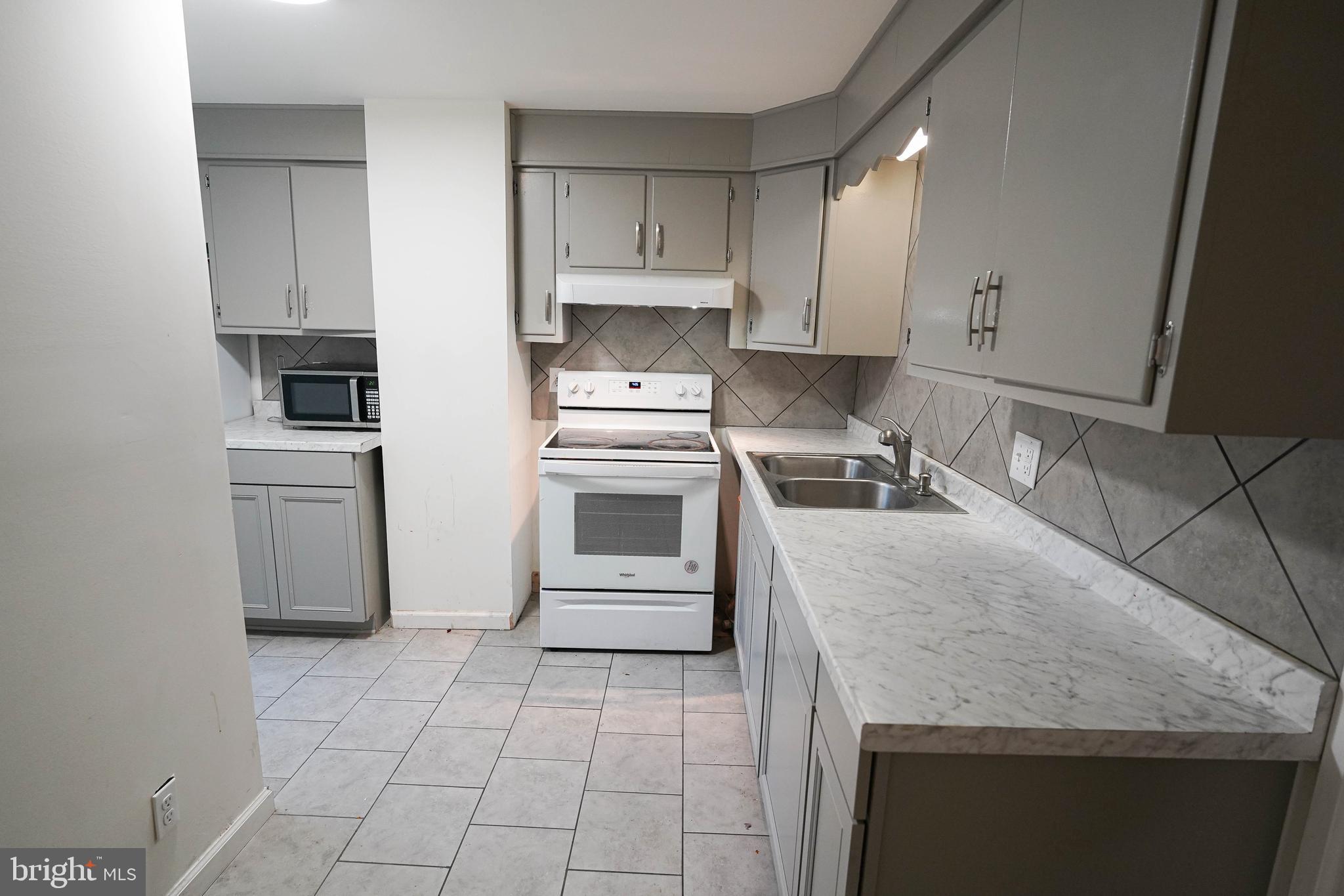 231 Newton Street, Unit A Salisbury, MD 21801 - Photo 29 of 38 a kitchen with granite countertop a stove sink and refrigerator
