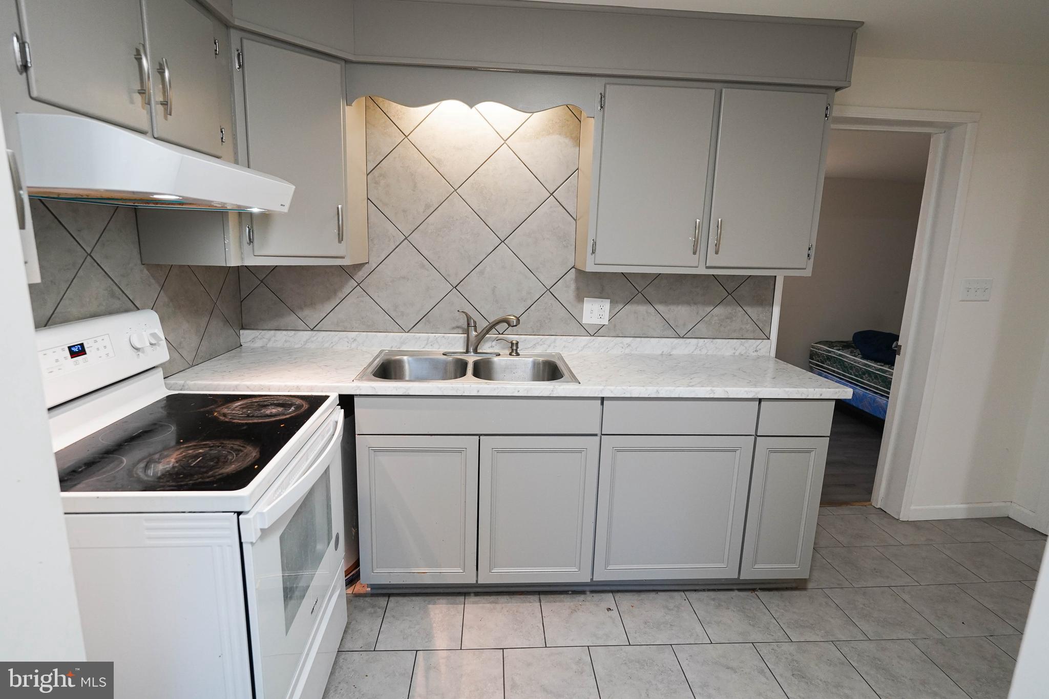 231 Newton Street, Unit A Salisbury, MD 21801 - Photo 32 of 38 a kitchen with a sink stove and cabinets