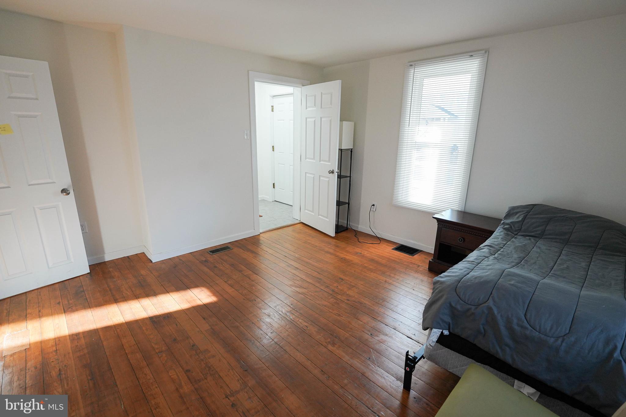 231 Newton Street, Unit A Salisbury, MD 21801 - Photo 9 of 38 a bedroom with a bed and wooden floor