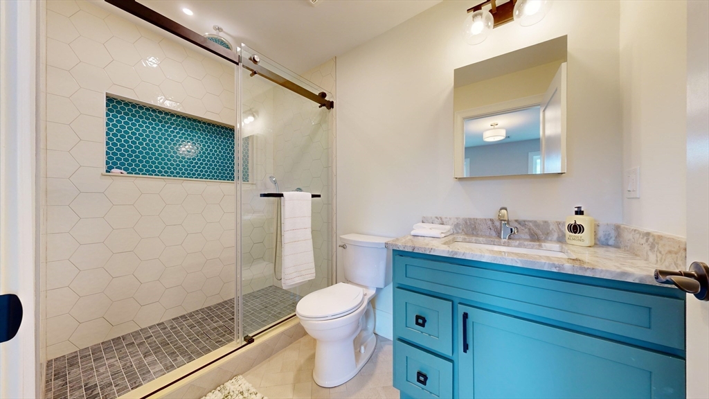 8 Charles Street North Reading, MA 01864 - Photo 28 of 42 a bathroom with a granite countertop sink a toilet and a mirror