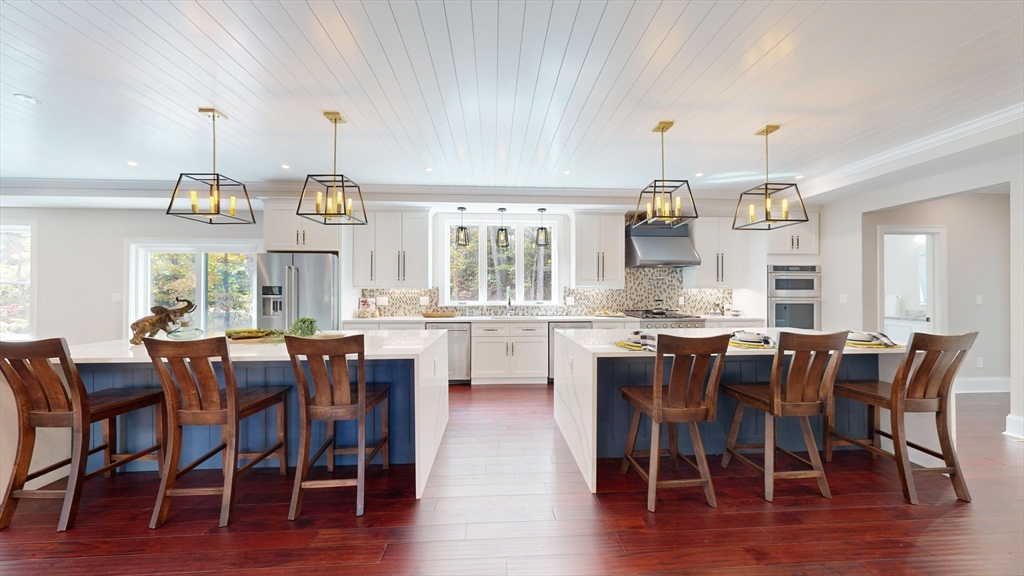 8 Charles Street North Reading, MA 01864 - Photo 3 of 42 a dining area with stainless steel appliances kitchen island granite countertop a table chairs and a view of living room
